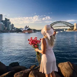 Woman holding flowers by Sydney Harbour on Mothers Day